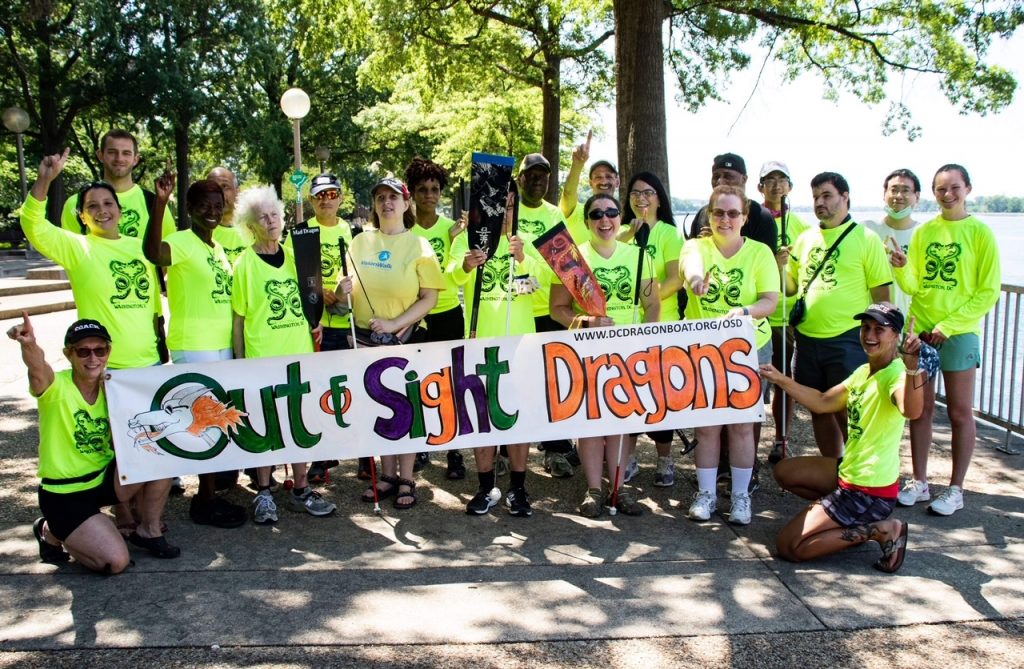 Picture of team with the Out of Sights Banner in front of the Titanic Memorial.